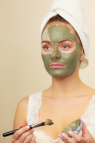 Woman applying with brush clay mud mask to her face  - Photo, Image
