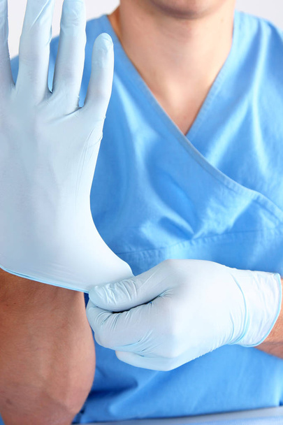 Γιατρό βάζοντας σε αποστειρωμένα γάντια απομονωμένες λευκό - Φωτογραφία, εικόνα
