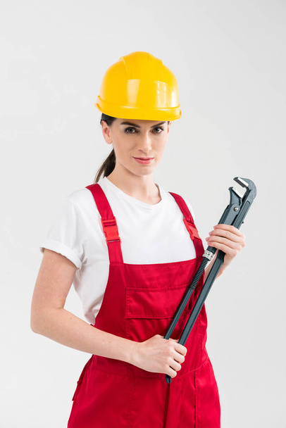Vrouwelijke bouwer bedrijf moersleutel - Foto, afbeelding