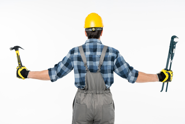 Workman holding hammer and pipe wrench  - Valokuva, kuva