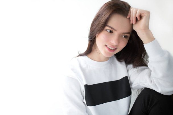 Cute woman in pullover sitting on white background - Фото, изображение