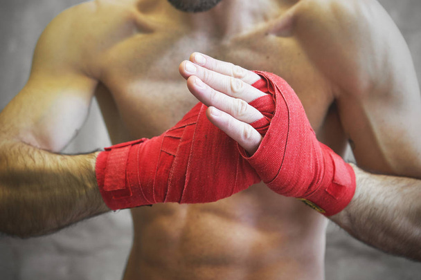 Disparo de manos envueltas con cinta de boxeo roja de pelea de boxeadores jóvenes
 - Foto, Imagen