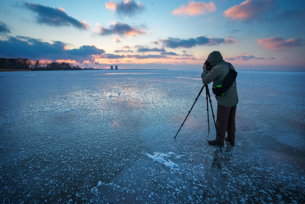 写真は冬の凍った川に夕日の写真を撮る - 写真・画像