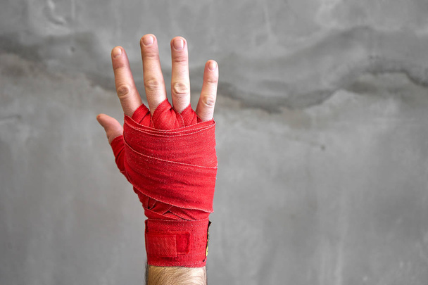 Oříznuté záběr ruky boxer je vnořen červenou boxu páskou - Fotografie, Obrázek