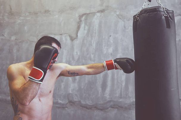 Boxer homme faisant de l'exercice avec sac de boxe
  - Photo, image