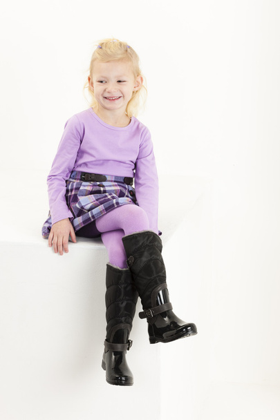 Little girl wearing boots sitting on chair - Zdjęcie, obraz