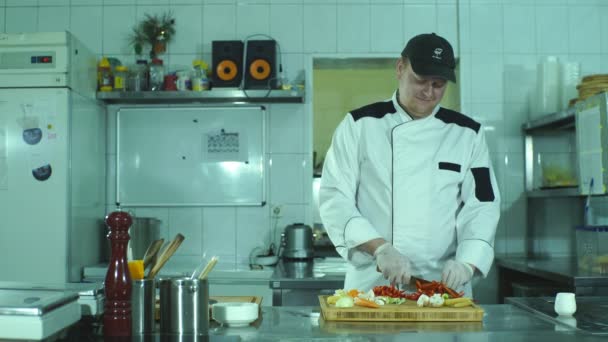 groenten op cutting board en chef-kok handen detail, de keuken van het restaurant op achtergrond - Video