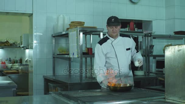 Een chef-kok wegknippen van groenten in een koekenpan - Video