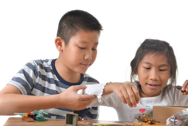 Asian boy and girl playing lego on white background. - Foto, afbeelding