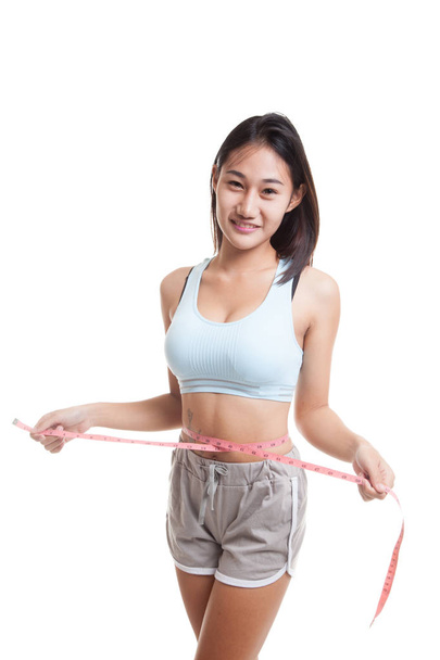 Beautiful Asian healthy girl measuring her waist. - Foto, imagen