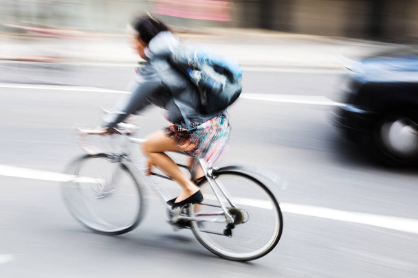 woman with bicycle in city traffic - Foto, Bild