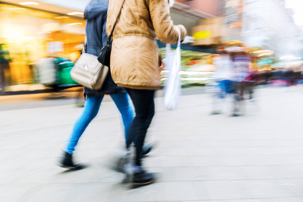 people walking on shopping street with motion blur - Foto, afbeelding