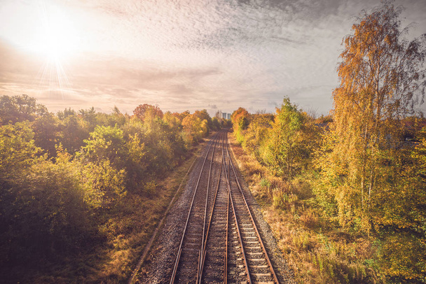 Railroad in autumn going to the city - 写真・画像