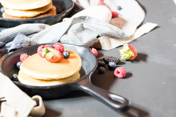 Home made pancakes with berries on metal frying pan decorated wi - Φωτογραφία, εικόνα