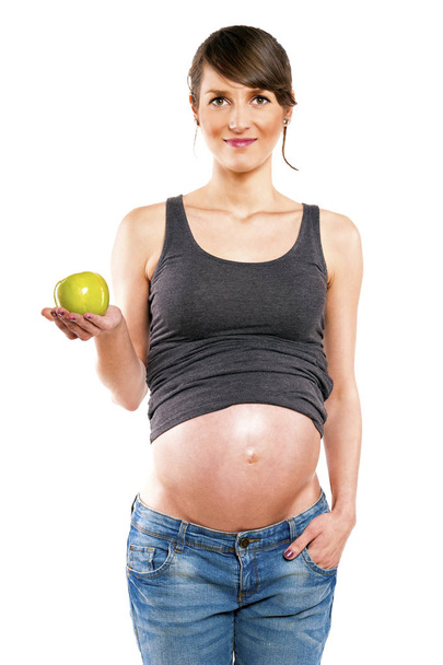 Mujer embarazada aislada sobre fondo blanco con manzana
. - Foto, Imagen