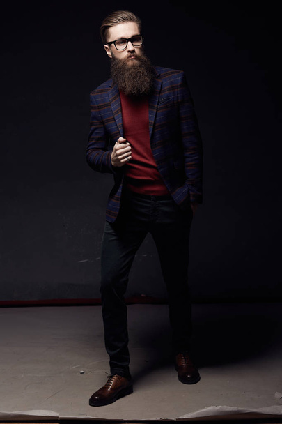 Handsome fashionable man with beard in dark studio - Photo, image