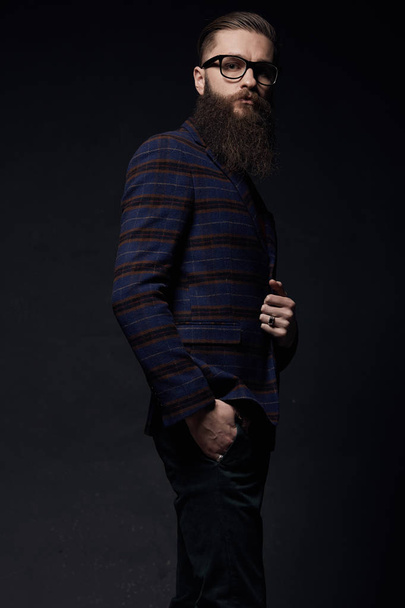 Beautiful stylish man with beard in dark studio - Фото, зображення