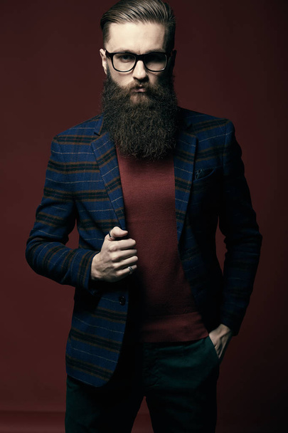 Serious stylish man with beard in dark studio - Photo, image
