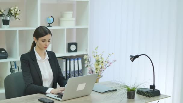 Young pretty business woman with notebook in the office - Video, Çekim