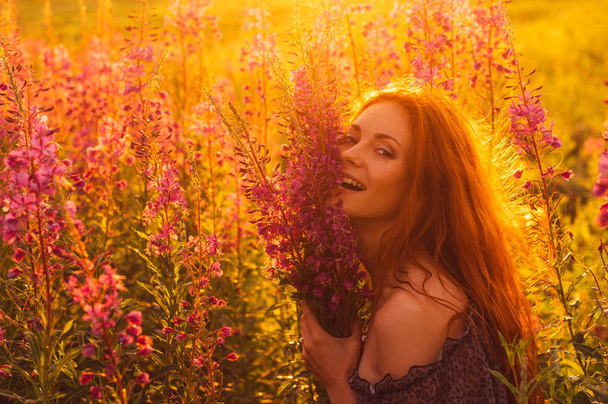 Усміхнена красива дівчина на полі, підсвічування сонця, схід сонця
 - Фото, зображення