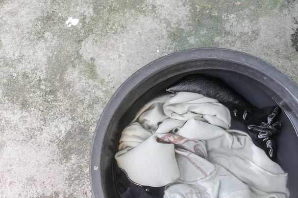zur Reinigung schmutzige Kleidung im Waschbecken schwarz einweichen - Foto, Bild