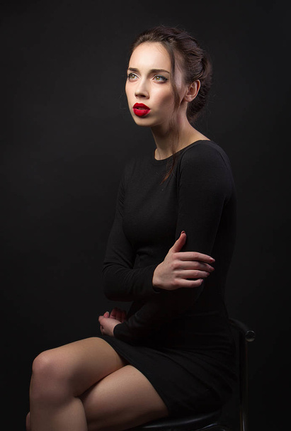 Portrait brunette girl in black dress. Red lips. Fashion - Foto, imagen