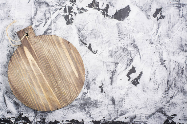 Handmade wooden cutting board on a gray marble background with space for text. - Zdjęcie, obraz