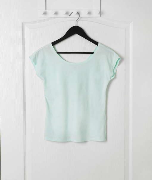 Blank t-shirt hanging on door - Φωτογραφία, εικόνα