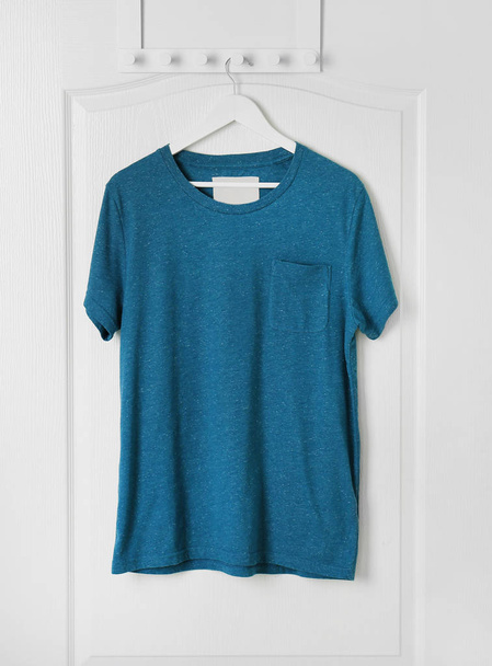 Blank t-shirt hanging on door - 写真・画像