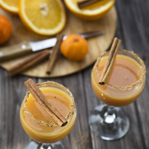 alcoholische drank met sinaasappelsap en kaneel - Foto, afbeelding