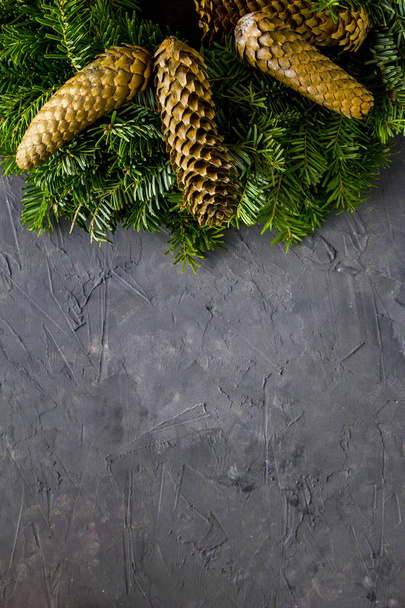 Рождественский еловый венок с шишками на бетонном фоне. Вид сверху с копирайтом
 - Фото, изображение