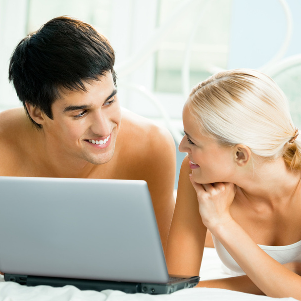Cheerful couple with laptop, at home - Foto, afbeelding