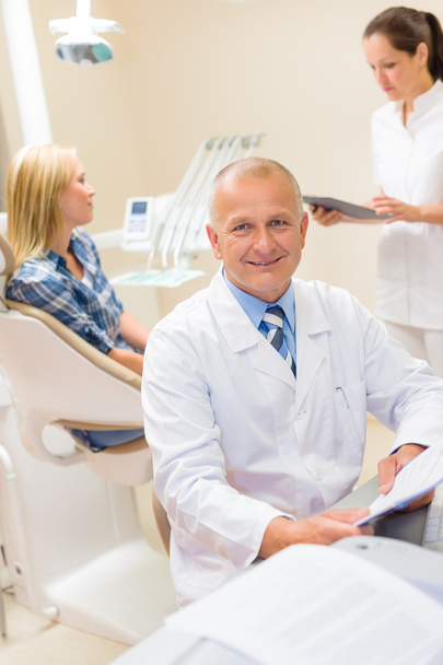 Mature dentist surgeon at office with patient - Foto, Imagen