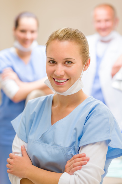 Улыбающаяся женщина-стоматолог с коллегами
 - Фото, изображение