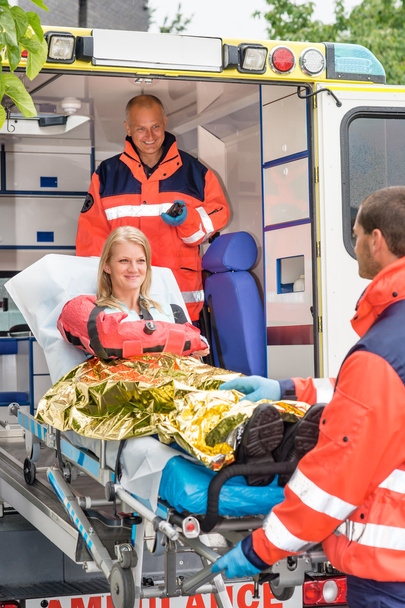 Paramedics helping woman on stretcher in ambulance - Foto, Imagem