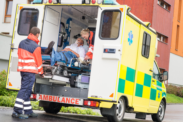 Ensihoitajat laittaa potilaan ambulanssi auton tuki
 - Valokuva, kuva