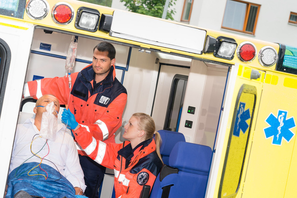 Paramedics checking IV drip patient in ambulance - Фото, изображение