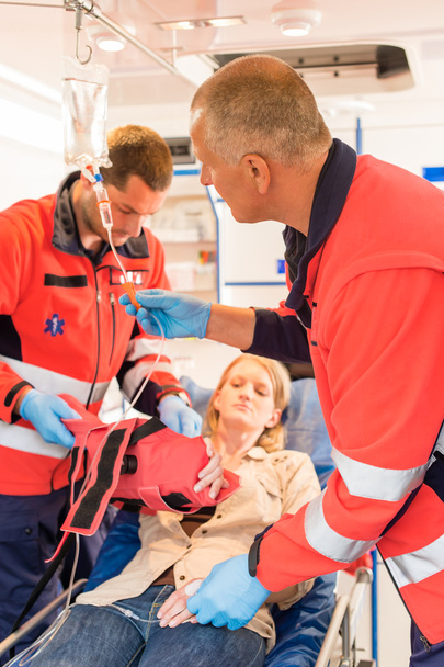 Paramedics in ambulance with patient broken arm - Foto, afbeelding