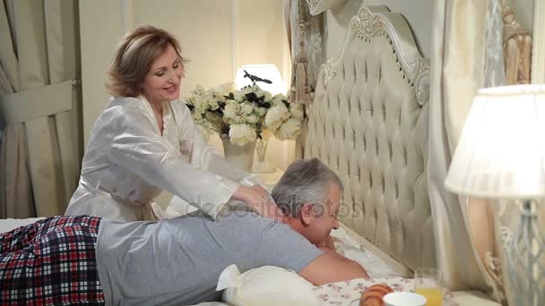 Donna matura che fa un massaggio all'uomo anziano a letto
 - Filmati, video