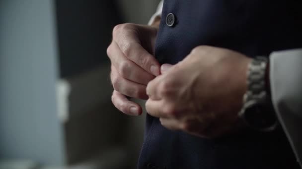 Man buttons up black waistcoat - Кадри, відео
