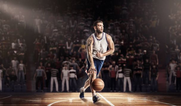 basketbalspeler in licht op professionele baan met bal - Foto, afbeelding