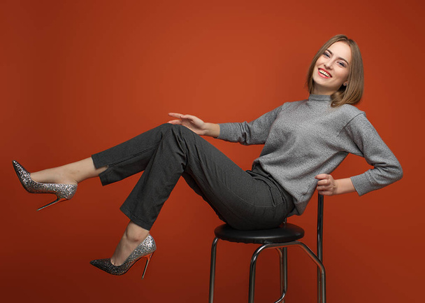Style in grey. Office look.  Model is posing on the Orange backg - Valokuva, kuva
