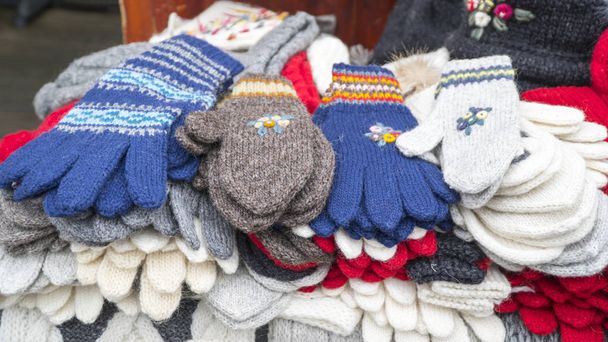 Groupe de chaussettes, mitaines, gants et chapeaux tricotés colorés faits main sur le marché
. - Photo, image