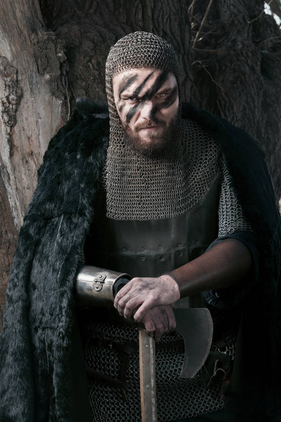 Viking in fur holding axe on the wild nature background - Fotografie, Obrázek