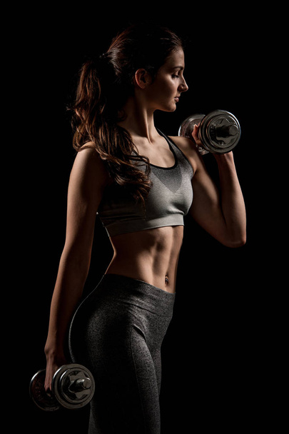 Atractive fit woman works out with dumbbells as a fitness concep - Photo, Image