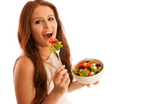 healthy eating  - woman eats a bowl of greek salad isolated over - Fotó, kép