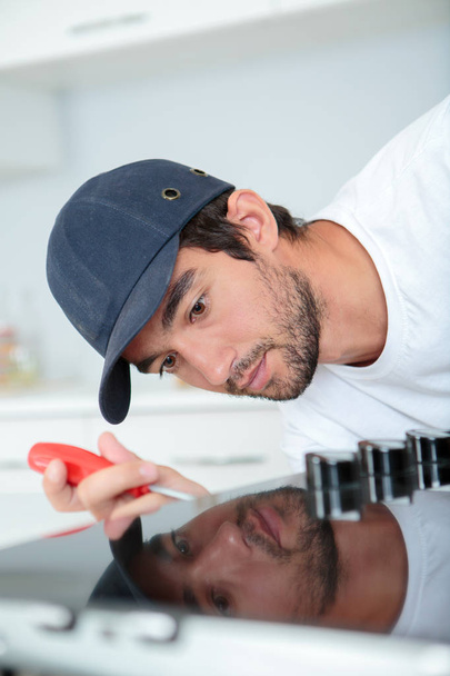 technician fixing a kitchen appliance - Fotografie, Obrázek