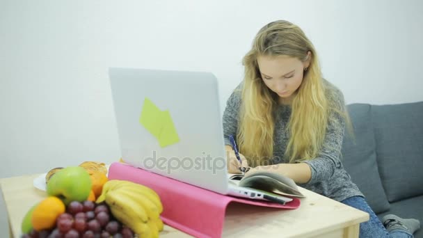 jeune étudiante faisant ses devoirs à la maison sur le canapé
 - Séquence, vidéo
