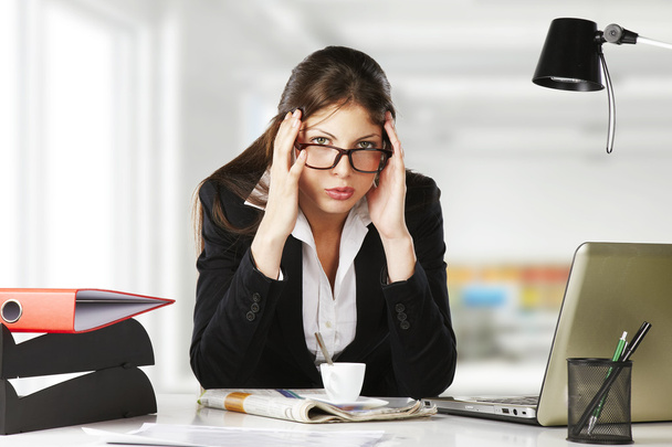 A young businesswoman is looking stressed as she works at her computer - 写真・画像
