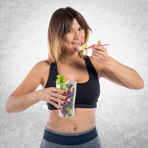 Bella donna sportiva mangiare un'insalata
 - Foto, immagini